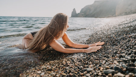 Woman Relaxing on the Rocky Shorelineの写真素材