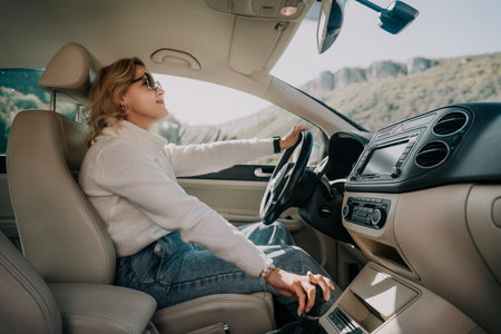 Woman in Sunglasses Driving a Car on a Sunny Dayの写真素材