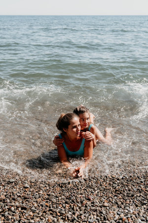 Mother and Daughter Embrace on a Pebble Beachの写真素材