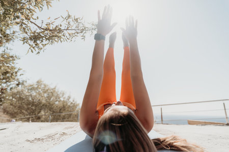 Young Woman Doing Yoga Pose Outdoors on a Sunny Dayの写真素材