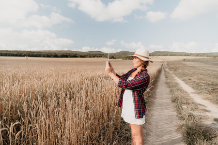 Young Woman in a Field Taking a Picture with a Tablet