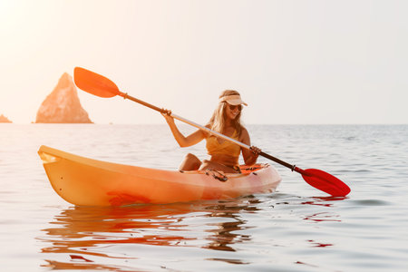 Woman Kayaking Ocean Paddle Sport - Young woman paddling a kayak in the ocean with a scenic background.の写真素材