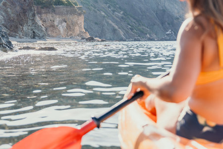 Kayaking, Sea, Coast - Woman kayaking on the sea with a beautiful coastline in the background.の写真素材