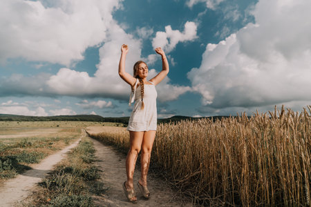 Woman in White Jumpsuit Dancing in a Wheat Fieldの写真素材