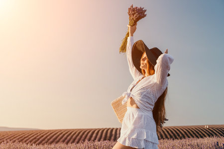 Woman in a White Dress and Hat Posing with Lavender Flowersの写真素材