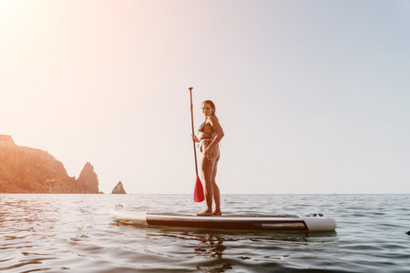 Woman Paddleboarding Ocean Coastline Calm Waterの写真素材