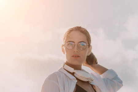 Young woman in glasses, freelancer with laptop working in summer park on sunset. Happy smiling girl relieves stress from work. Freelance, remote work, digital nomad, travel conceptの写真素材