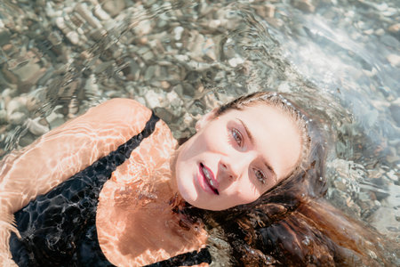 Woman Floating in Clear Waterの写真素材