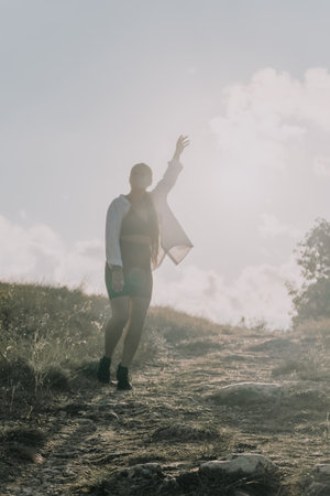 Man Mountain Victory - A man raises his fist in triumph on a mountaintop, celebrating a successful...