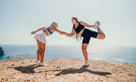 Two Athletic Women Stretching on a Clifftopの写真素材