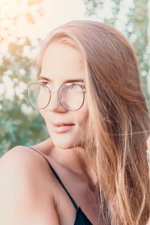 Woman Glasses Portrait Outdoors - A close-up portrait of a woman wearing glasses outdoors.の写真素材