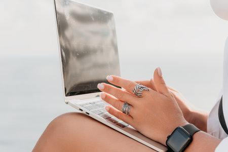 Laptop, Woman, Work - A woman works on her laptop while sitting on a beach.の写真素材
