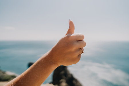 Thumbs Up Gesture Against the Oceanの写真素材