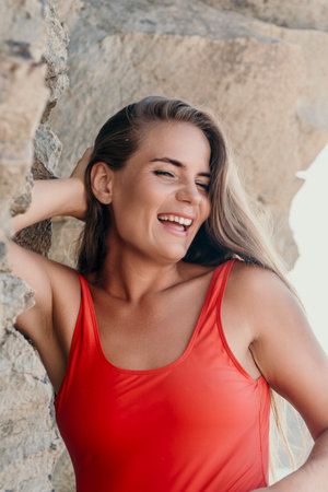 Laughing Woman in Red Swimsuit Near a Rocky Cliffの写真素材