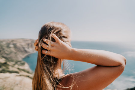 Woman with Long Hair Gazing at the Oceanの写真素材