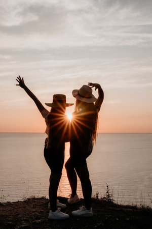 Two Women in Silhouettes Enjoying a Sunsetの写真素材