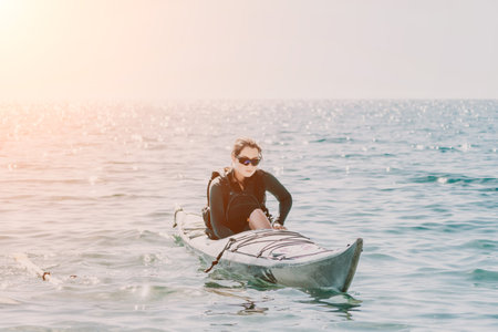 Kayaking Woman Ocean Paddle Sports - Woman paddling kayak on calm ocean water at sunset.の写真素材