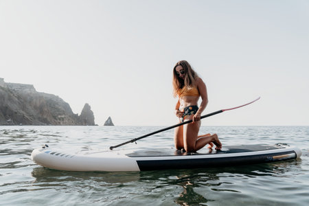 Woman Paddleboard Ocean - Woman kneeling on a paddleboard in the ocean on a calm sunny day.