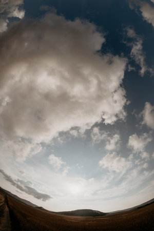 Wide-Angle View of a Field Under a Cloudy Skyの写真素材