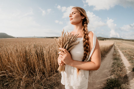Woman Holding Wheat in a Fieldの写真素材