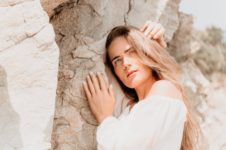 Woman, Rock, Beach - Portrait of a woman standing by a rock formation on a beach.の写真素材