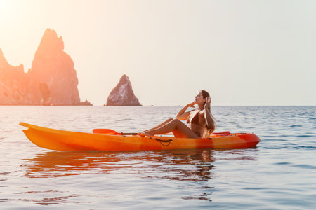 Kayaking Woman Sea Mountain Scenic View: A woman in a swimsuit kayaks in calm waters near a scenic mountain range.の写真素材
