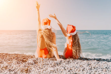 Christmas at the Beach: Mother and Daughter in Santa Hatsの写真素材