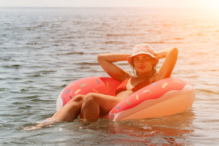 Woman, Beach, Inflatable: Relaxing on an inflatable donut float in the ocean.