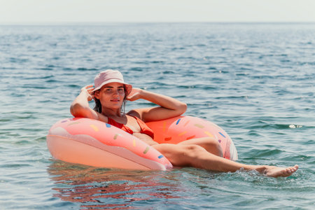 Woman, Inflatable, Beach - Relaxing on an inflatable ring in the sea.