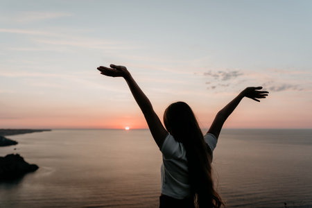 Silhouette of a Woman with Open Arms Facing the Sunset
