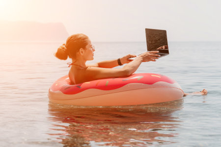 Woman Laptop Beach - Working on a laptop while floating in a pool on a summer day.