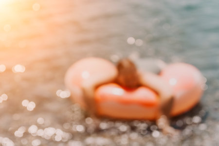 Child Float Beach Summer - Blurred Image of a child on a float in the water on a sunny day.