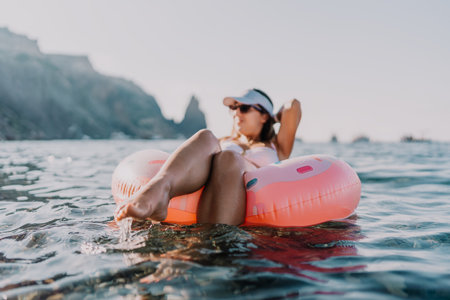 Woman floating ocean, relaxing on an inflatable ring enjoying summer vacation