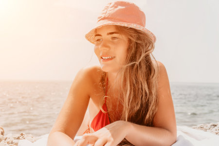 Beach Woman Sunbathing Hat Summer - A woman in a bikini and hat sunbathes on a beach.の写真素材