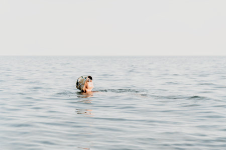Woman Swimming Ocean Water - A woman swims in the ocean, enjoying the water and the open space.