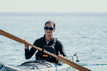 Kayaking Woman Paddle Ocean - A woman in a kayak with a paddle, wearing sunglasses and a life vest,...