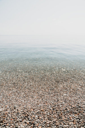 A calm body of water with a few rocks scattered throughoutの写真素材