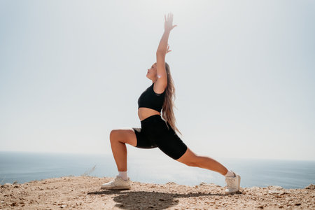 Woman Doing Yoga Pose on Clifftop with Ocean Viewの写真素材