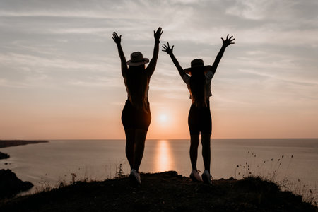 Silhouettes of Two Women Celebrating Sunset