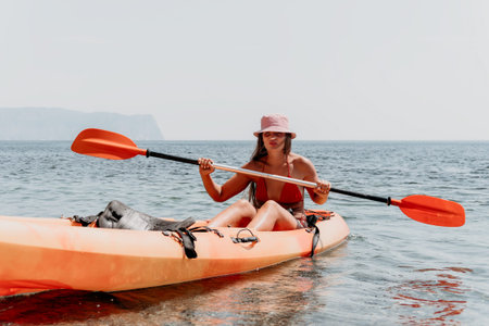 Kayaking Woman Ocean Paddle Smiling - Woman kayaking in ocean, smiling, holding paddle.