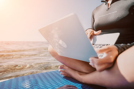 Laptop Beach Work Woman working on a laptop on the beach at sunset.