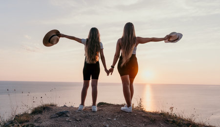 Mother and Daughter Embrace the Sunset on a Clifftopの写真素材