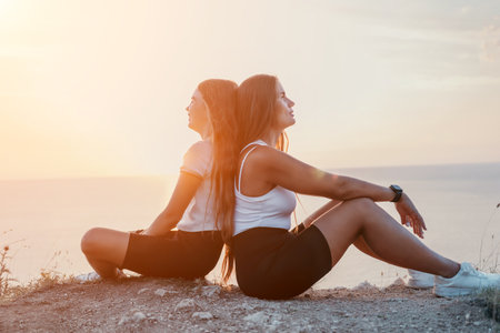 Two Young Women Admiring the Sunset Togetherの写真素材