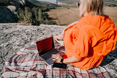 Woman Working on Laptop with a Stunning Viewの写真素材