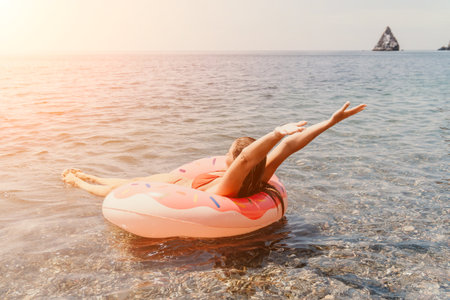 Woman Inflatable Ring Ocean Summer Vacation - Woman enjoying a sunny day floating on an inflatable ring in the ocean.の写真素材