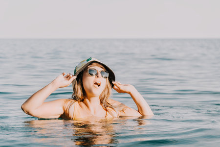 Woman Beach Sunglasses Hat Enjoying Water Summertime Relaxationの写真素材