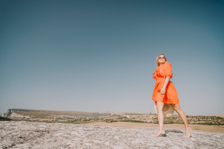 Woman in Red Dress Walks Towards the Horizonの写真素材