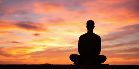 Person Meditating at Sunset Silhouette of a person sitting in a meditative pose, facing a colorful sunset. The sky isの素材