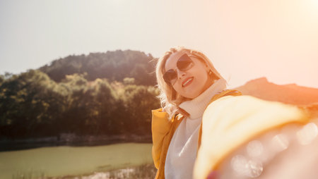 Woman Sunglasses Selfie Landscape - Happy woman taking a selfie with sunglasses while enjoying the sunny landscape.の写真素材