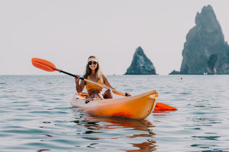 Kayaking Woman Sea Coastline Scenic Landscape - Female paddler enjoys kayaking with scenic coastline view.の写真素材